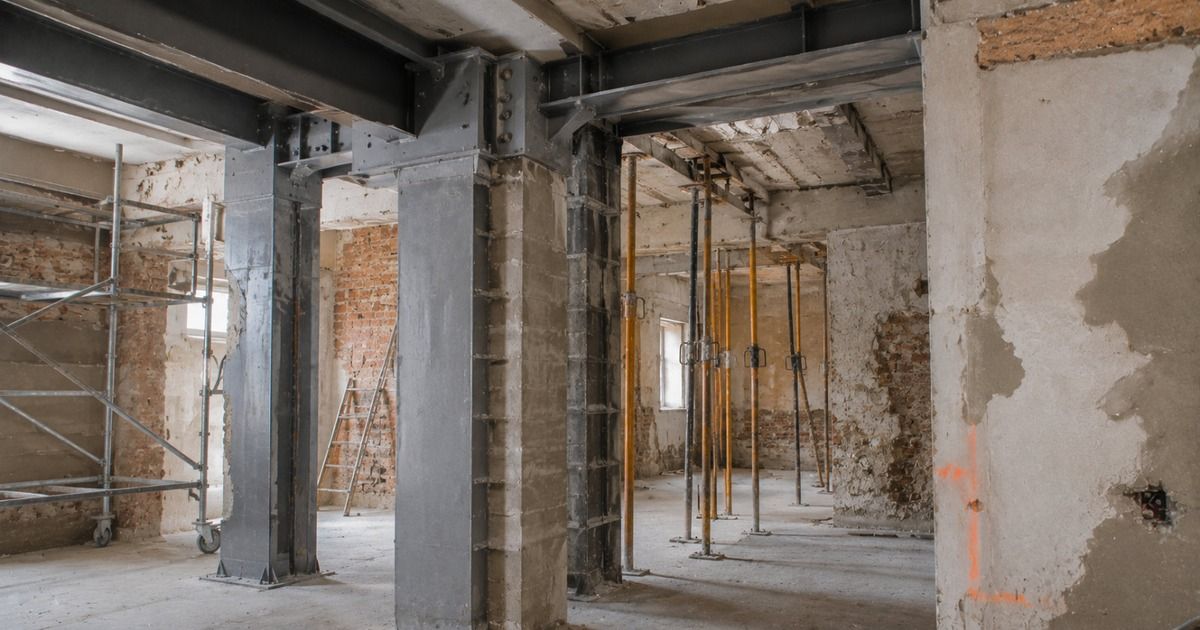 Obra de refuerzo estructural con vigas metálicas y puntales en el interior de un edificio